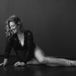 Frau liegt auf dem Boden und lacht bei ihrem Boudoirfotoshooting